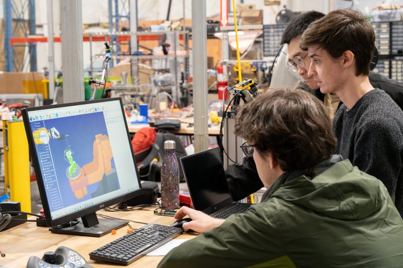 Students gathered around a computer screen.