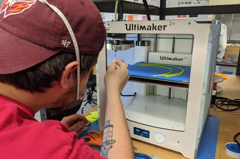 Student assisting with the 3D printing process.