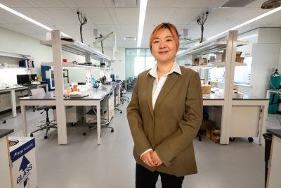 Materials science researcher stands in lab.